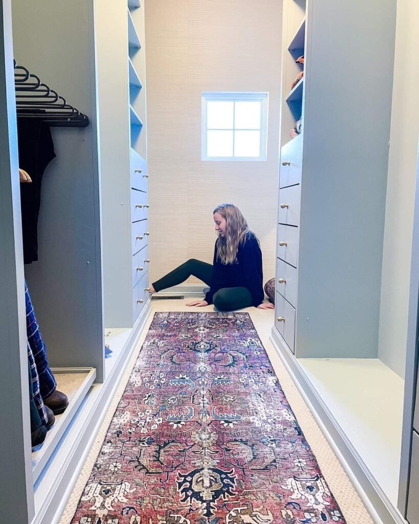 The women sat on the floor, with a closet cabinet on the side and a rug in the center.